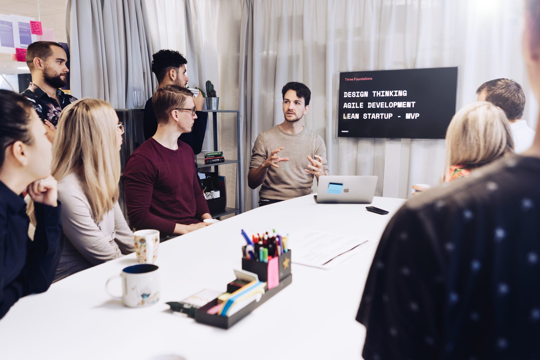 Presenting the three foundations — design thinking, agile development, lean startup — to a team around a table at Daresay.